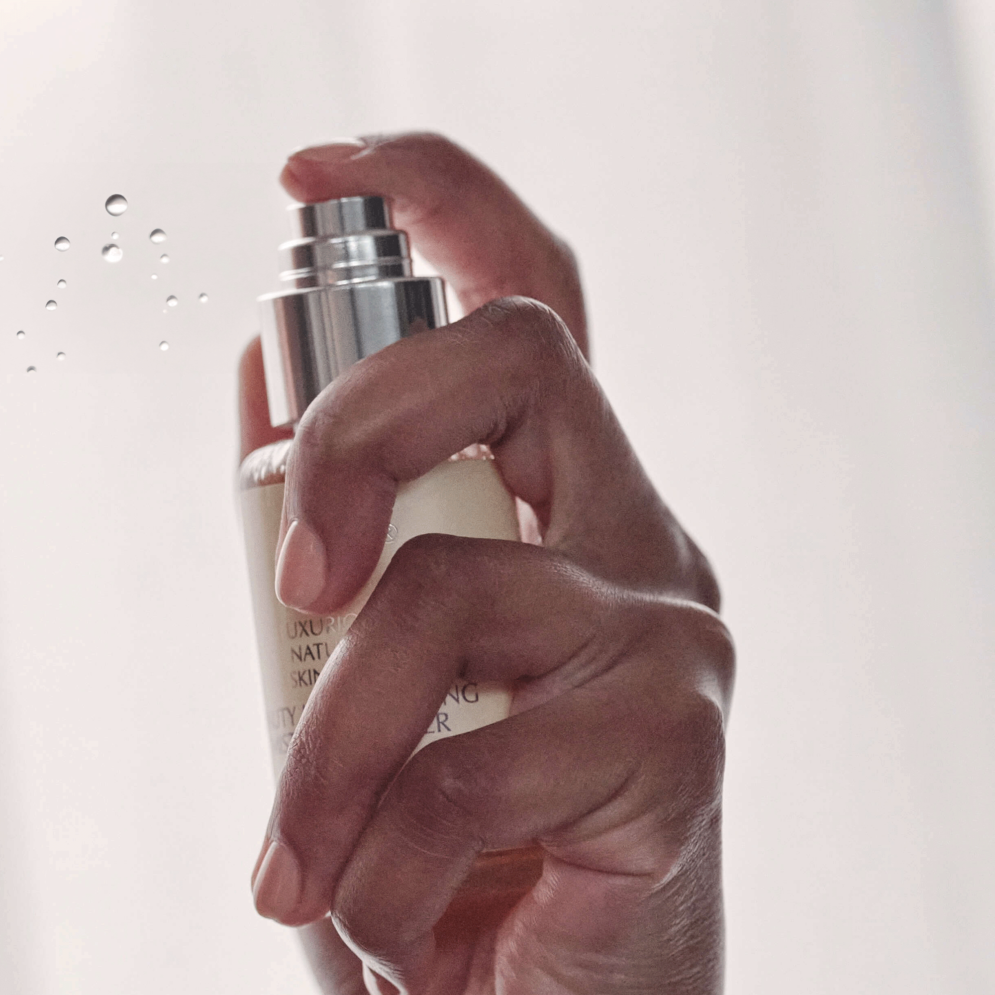 Close-up of a hand spraying a JK7 Face mist from a pump bottle