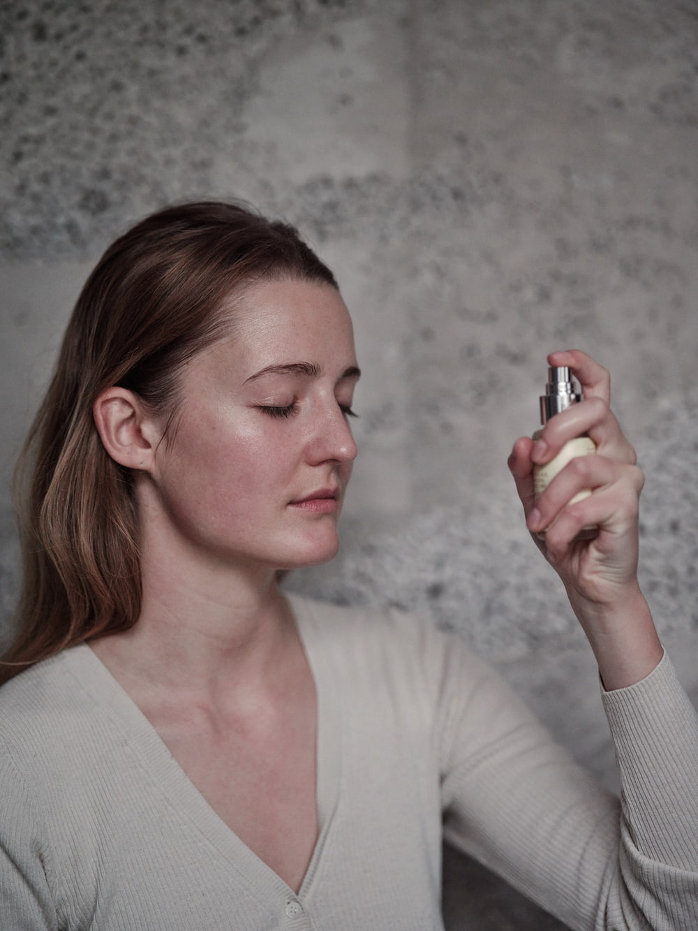 Woman using JK7 beauty moisturizing mist on a natural background