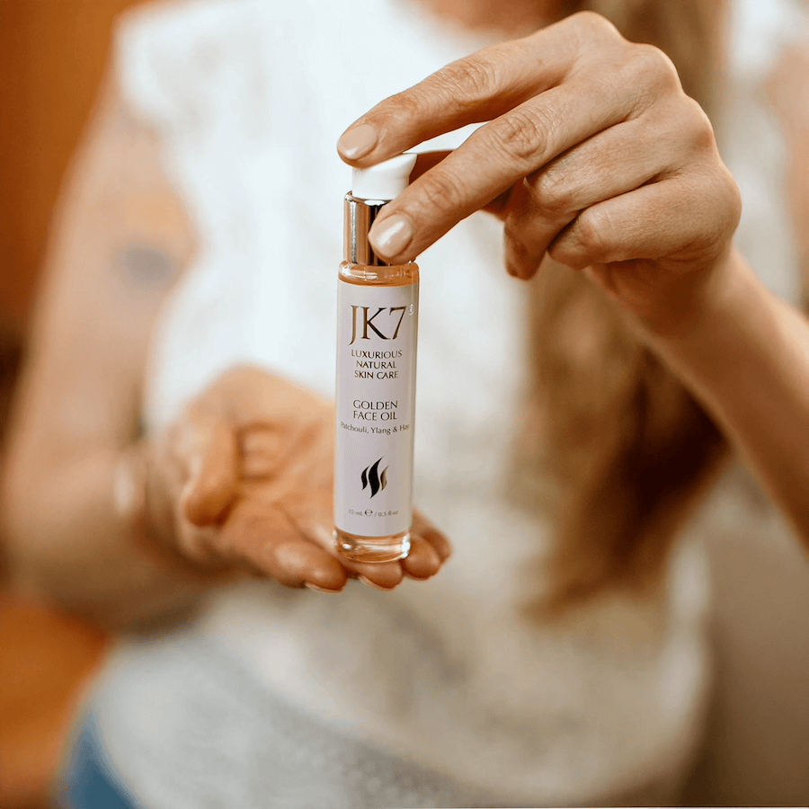 Woman holding a bottle of JK7 Golden Face Oil