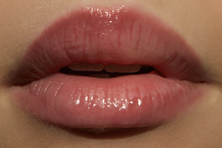 Close-up of glossy pink lips with a soft, hydrated finish.