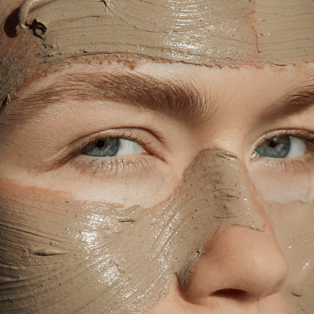 Close-up of a woman wearing a mineral face mask.